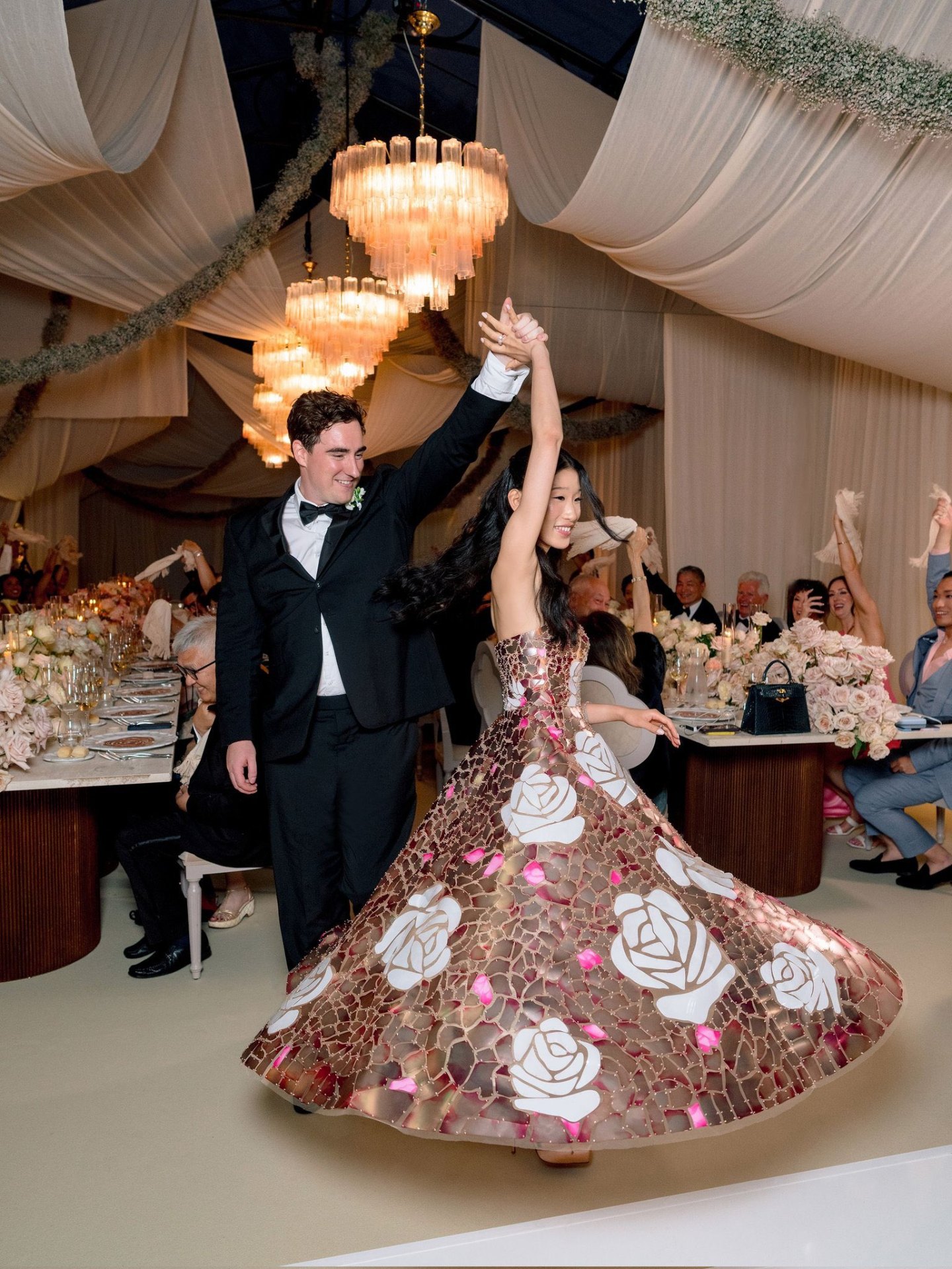 Becca Bloom and her groom during their first dance at their Lake Como wedding, her mosaic-rose gown sweeping across the floor